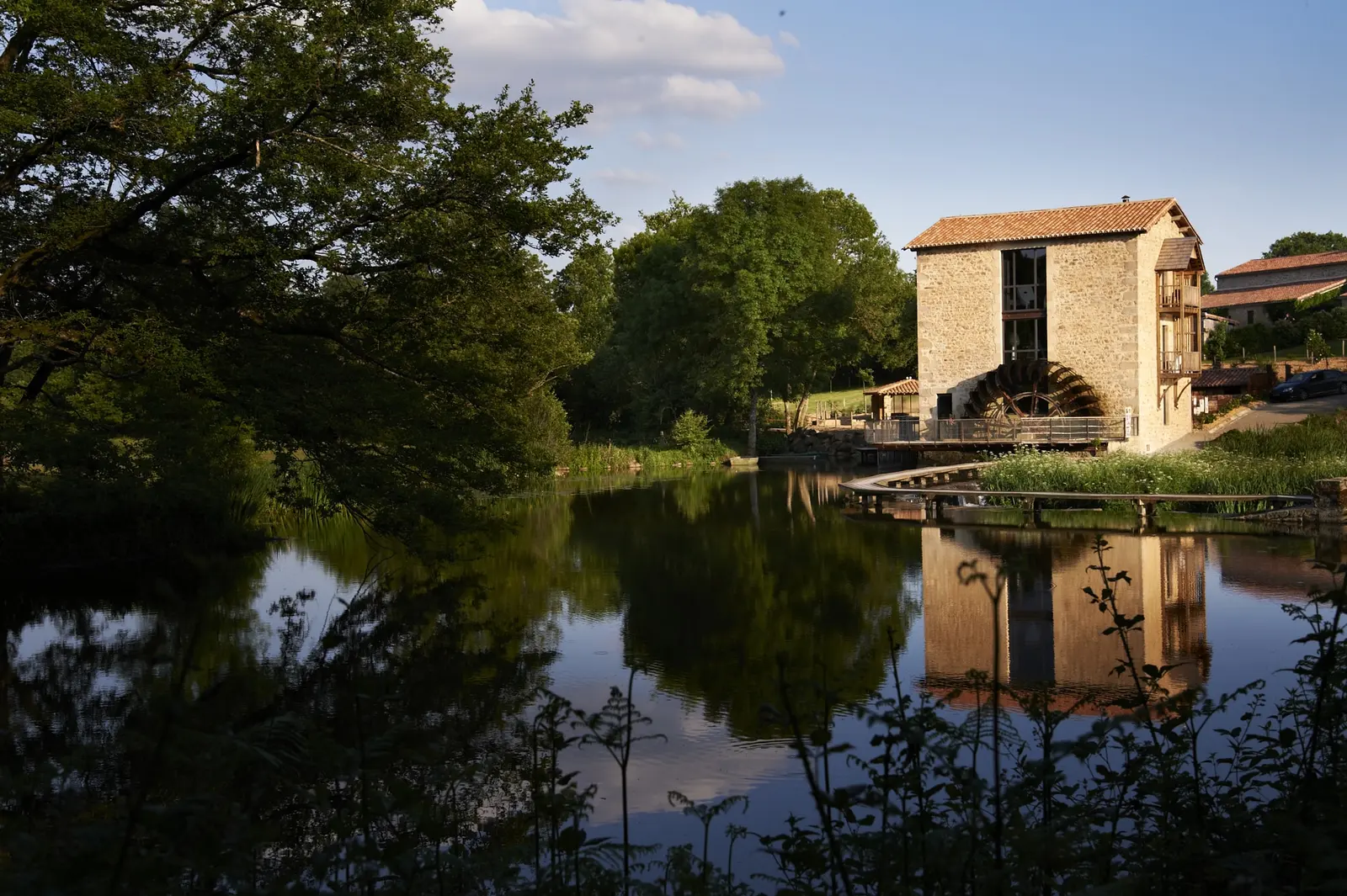 Le Moulin de la Roche et sa roue à aubes se reflétant dans l'étang
